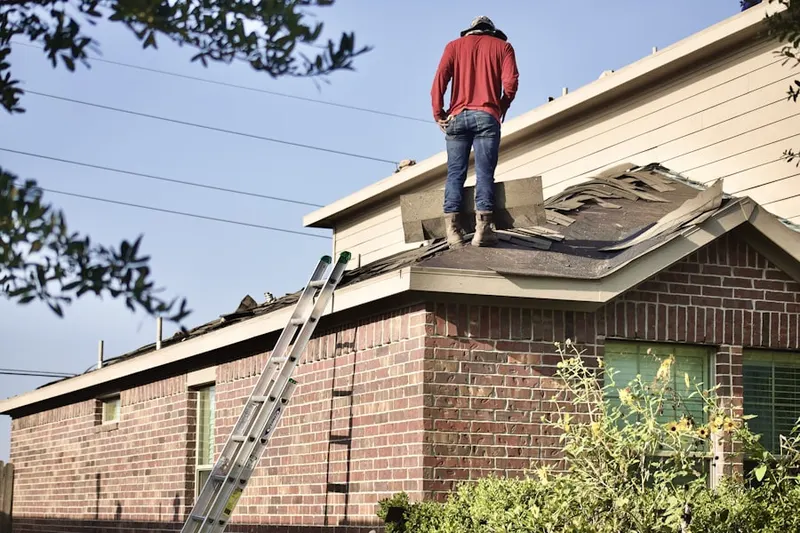 Professional roofer working on a residential roof in Tidwell